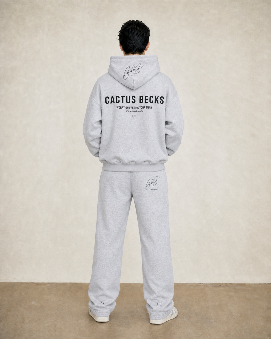 Person wearing a gray 'Cactus Becks' hoodie and pants against a beige background