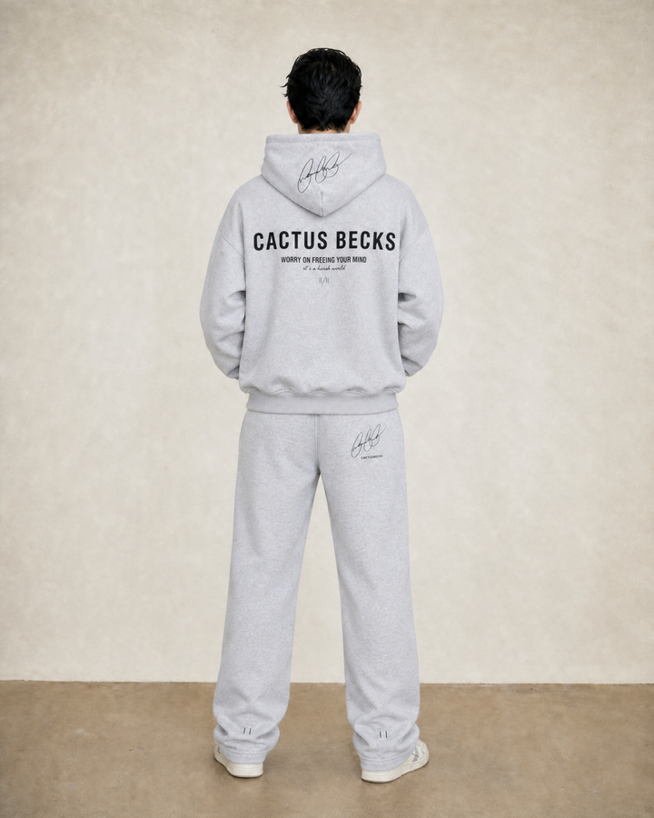 Person wearing a gray 'Cactus Becks' hoodie and pants against a beige background