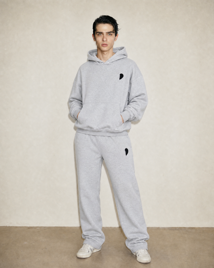Person wearing a 'Cactus Becks' tracksuit with a broken heart on a beige background