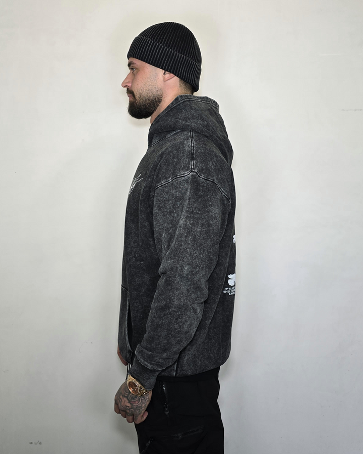Person wearing a dark gray hoodie and black beanie against a white background